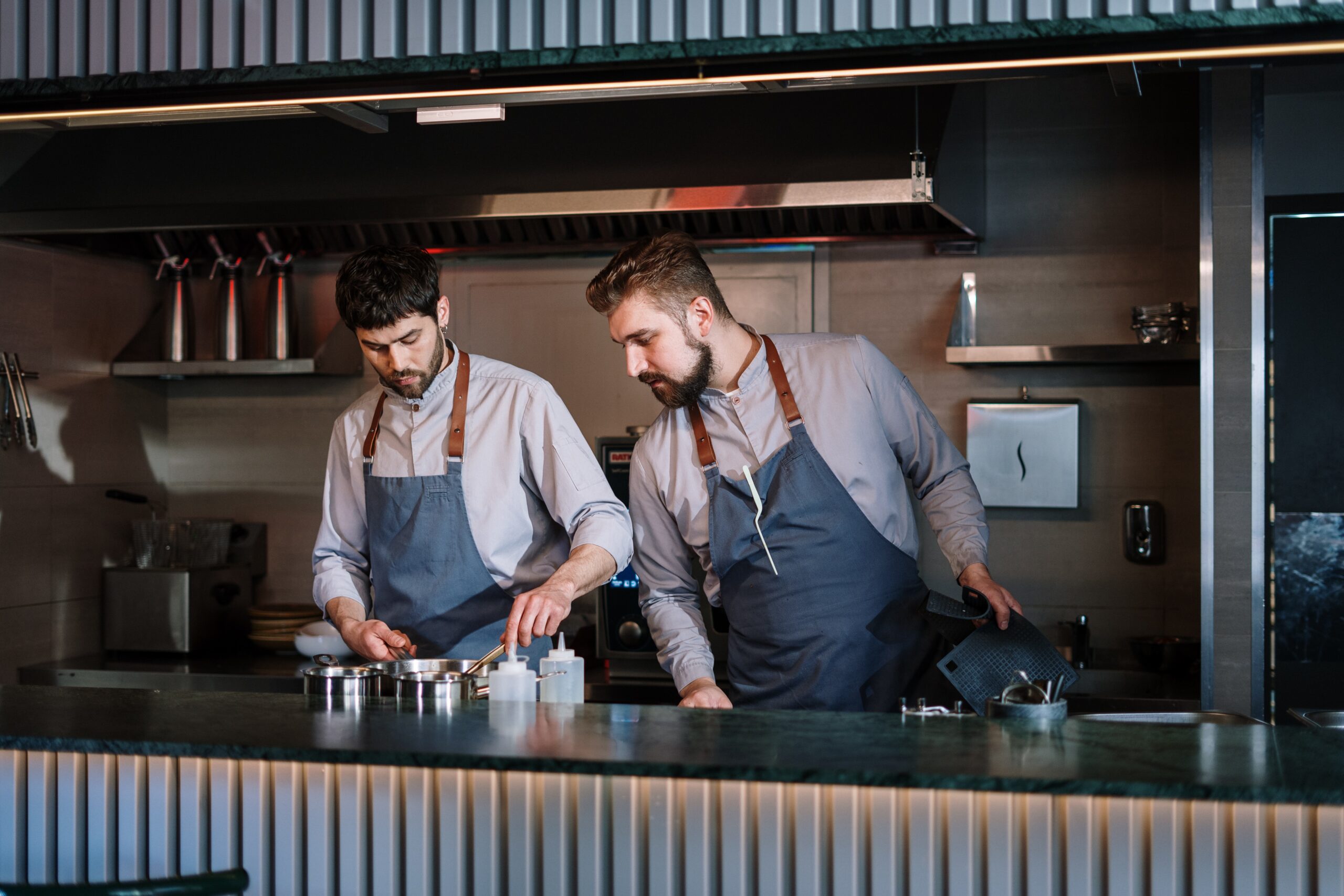 Two kitchen staff working in a restaurant. Blog: Promoting New Leaders